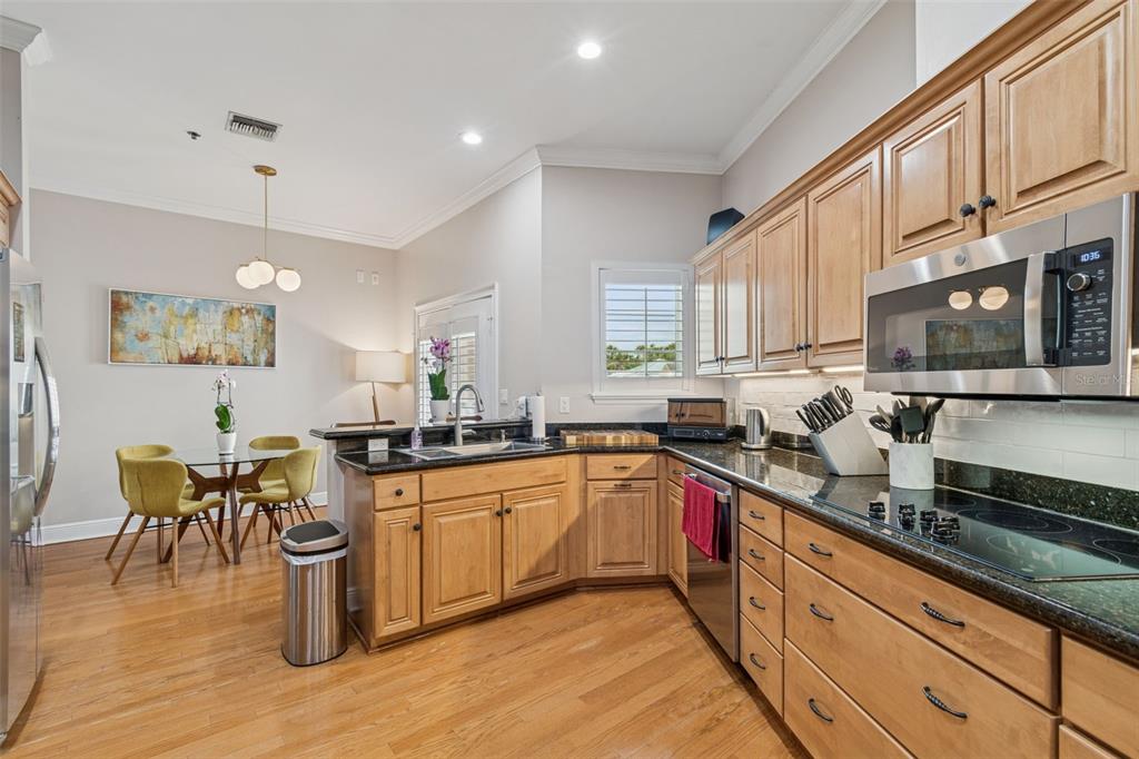 1001 South Rome Avenue, Unit 9 Tampa, FL 33606 - Photo 12 of 25 a kitchen with stainless steel appliances granite countertop wooden cabinets a sink a stove a dining table and chairs