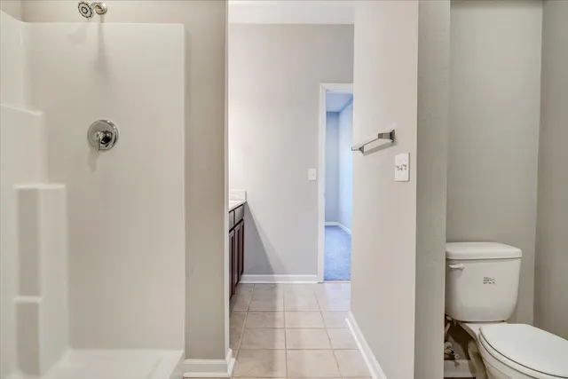 a bathroom with a granite countertop shower and a toilet