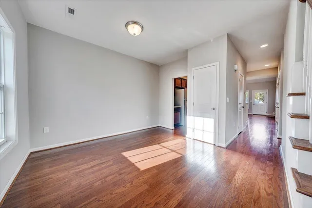 a view of empty room with wooden floor
