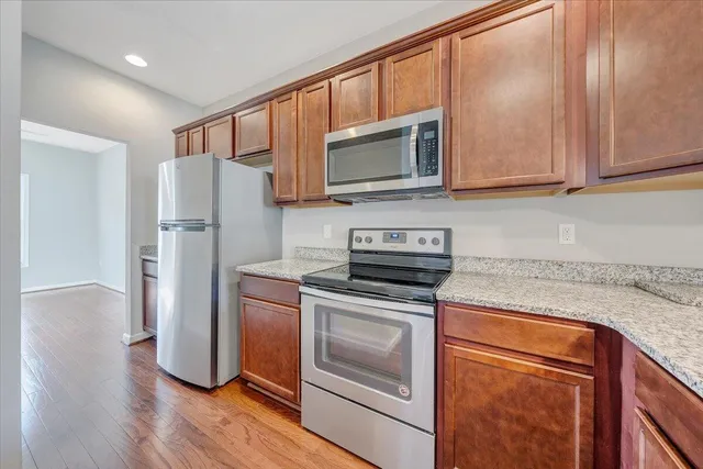 a kitchen with stainless steel appliances granite countertop a stove a refrigerator and a microwave