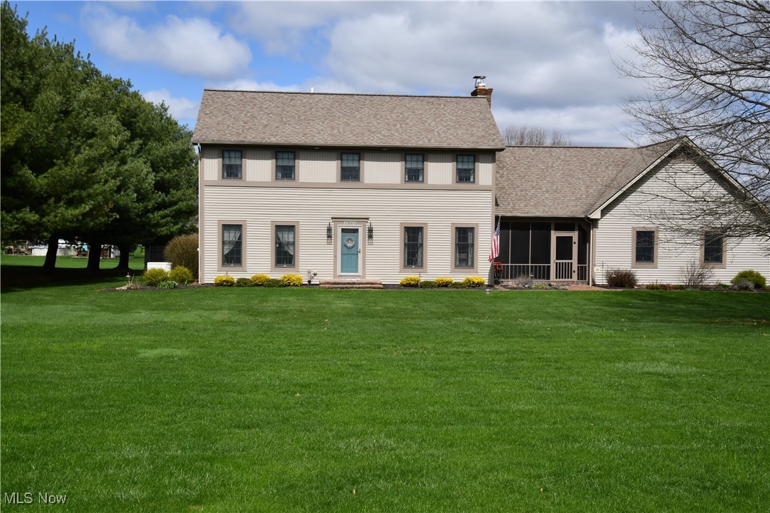 3180 West Calla Road Canfield, OH 44406 - Photo 1 of 49 Front of house featuring a sunroom, a chimney, a shingled roof, and a lawn