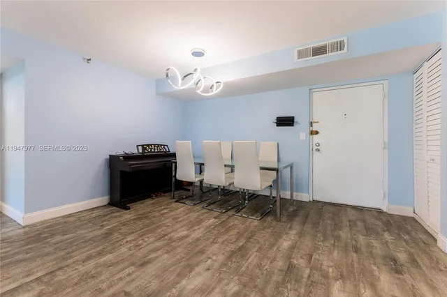 an empty room with wooden floor and ceiling fan
