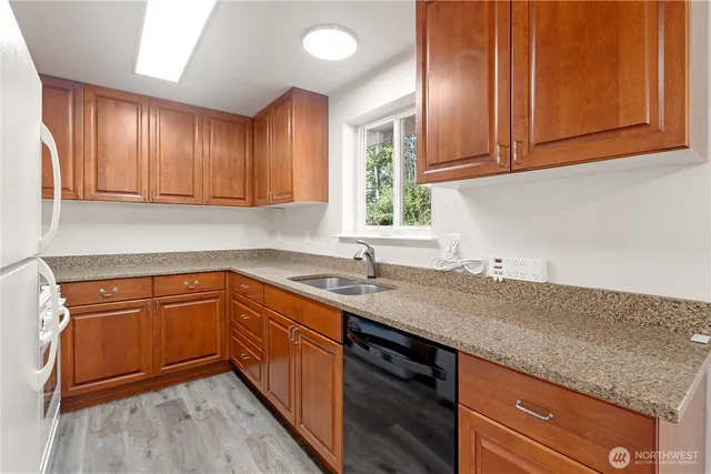 a kitchen with granite countertop cabinets sink and window