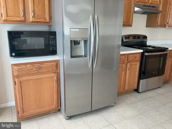 a kitchen with stainless steel appliances granite countertop a refrigerator and a stove top oven