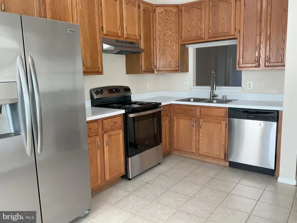 a kitchen with stainless steel appliances granite countertop a stove a refrigerator and a sink