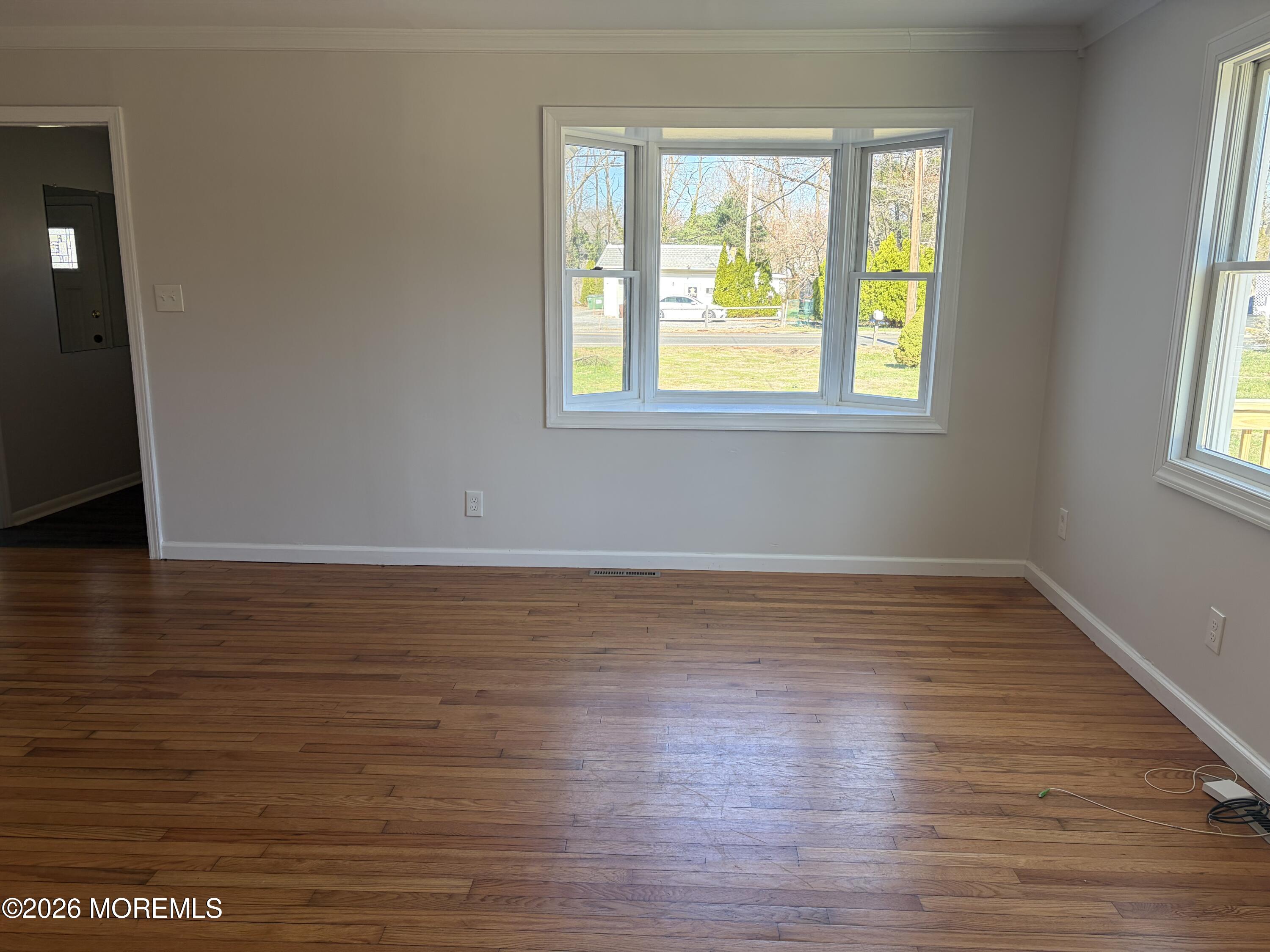 633 Hulses Corner Road Howell, NJ 07731 - Photo 3 of 11 a view of an empty room with wooden floor and a window