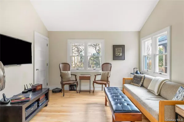 a living room with furniture a flat screen tv and a window