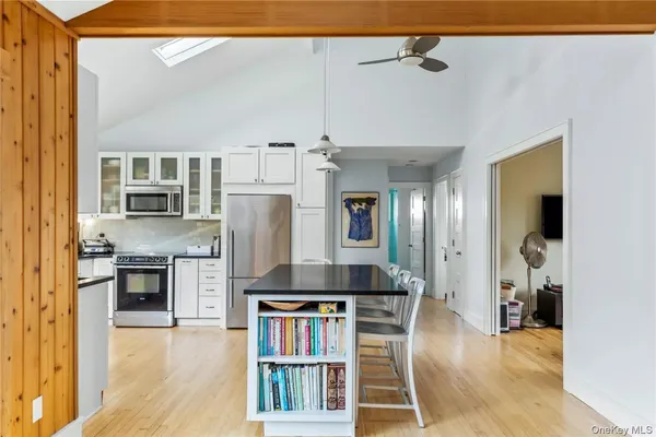 a kitchen with stainless steel appliances kitchen island granite countertop a refrigerator a stove and a sink with granite countertops