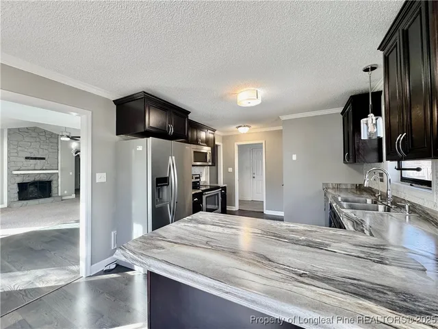 a kitchen with kitchen island sink stove and refrigerator