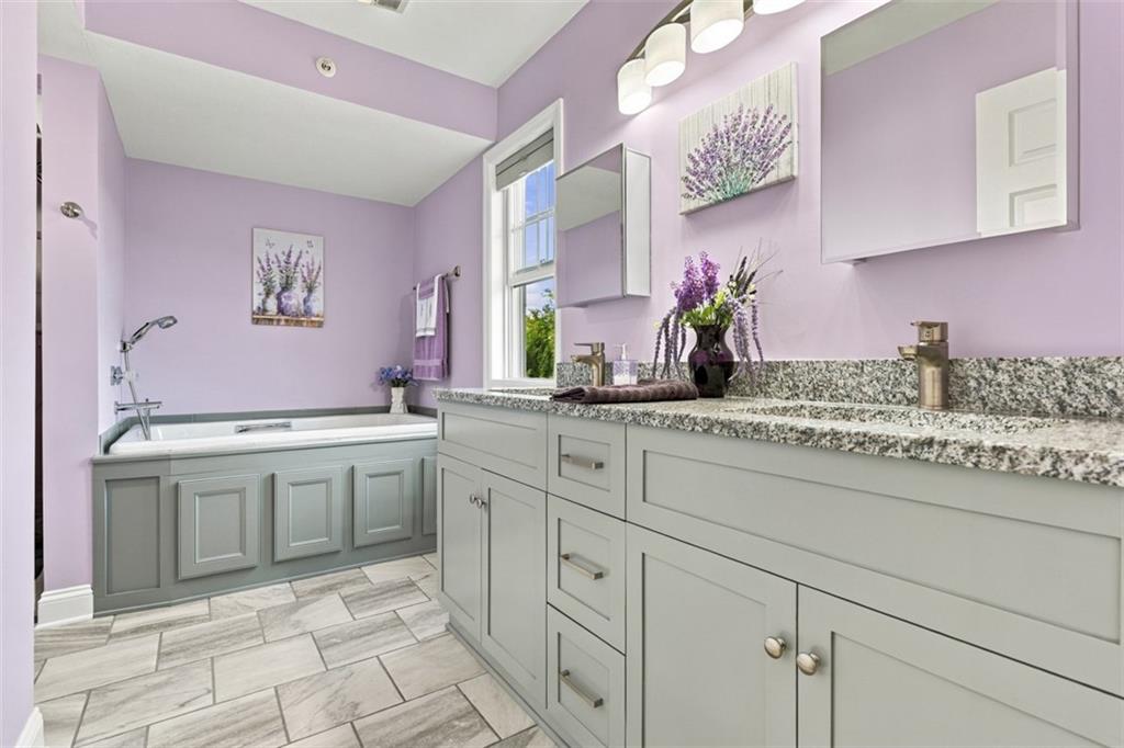 154 Rifgon Drive Canonsburg, PA 15317 - Photo 10 of 42 Luxurious primary en suite featuring dual vanities with granite countertops, tile flooring and a spacious soaking tub.
