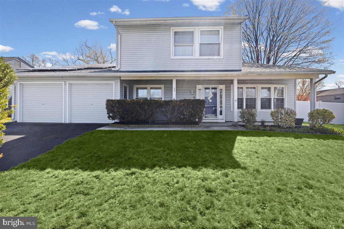 a front view of a house with a yard and potted plants