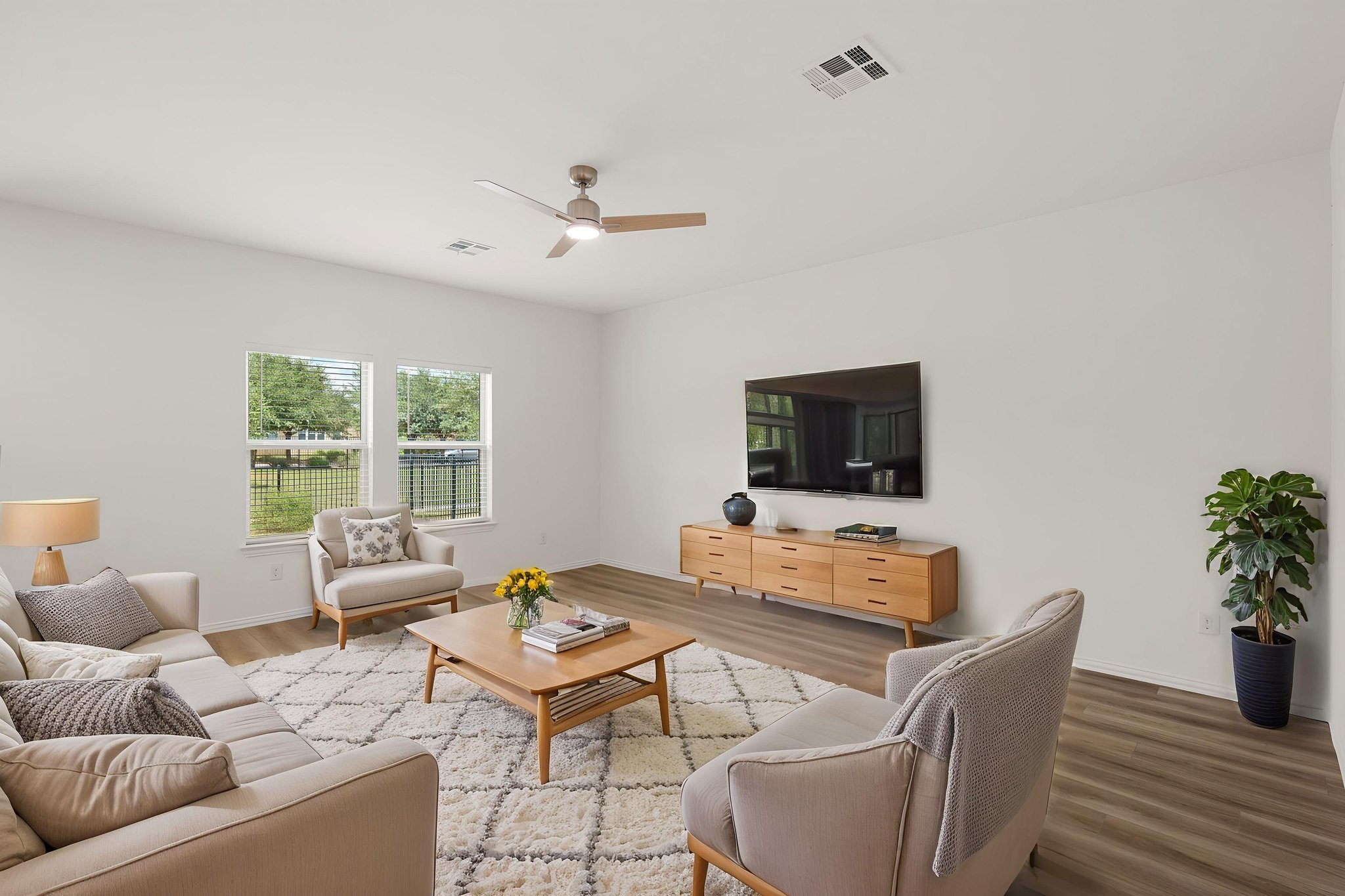 155 Rains Kyle, TX 78640 - Photo 3 of 25 A well-lit gathering space with hard surface flooring offers views of the verdant yard through broad windows.