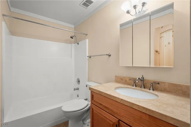 a bathroom with a granite countertop sink a toilet and shower
