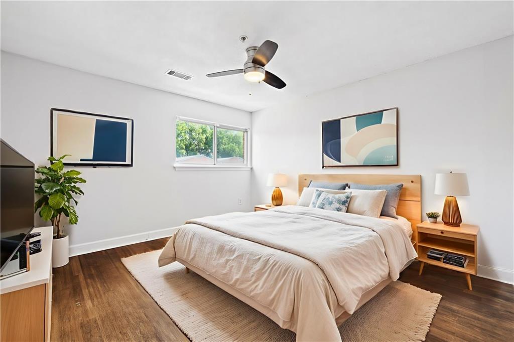 383 Ralph McGill Boulevard Northeast, Unit J Atlanta, GA 30312 - Photo 14 of 28 a bedroom with a bed and a wooden floor