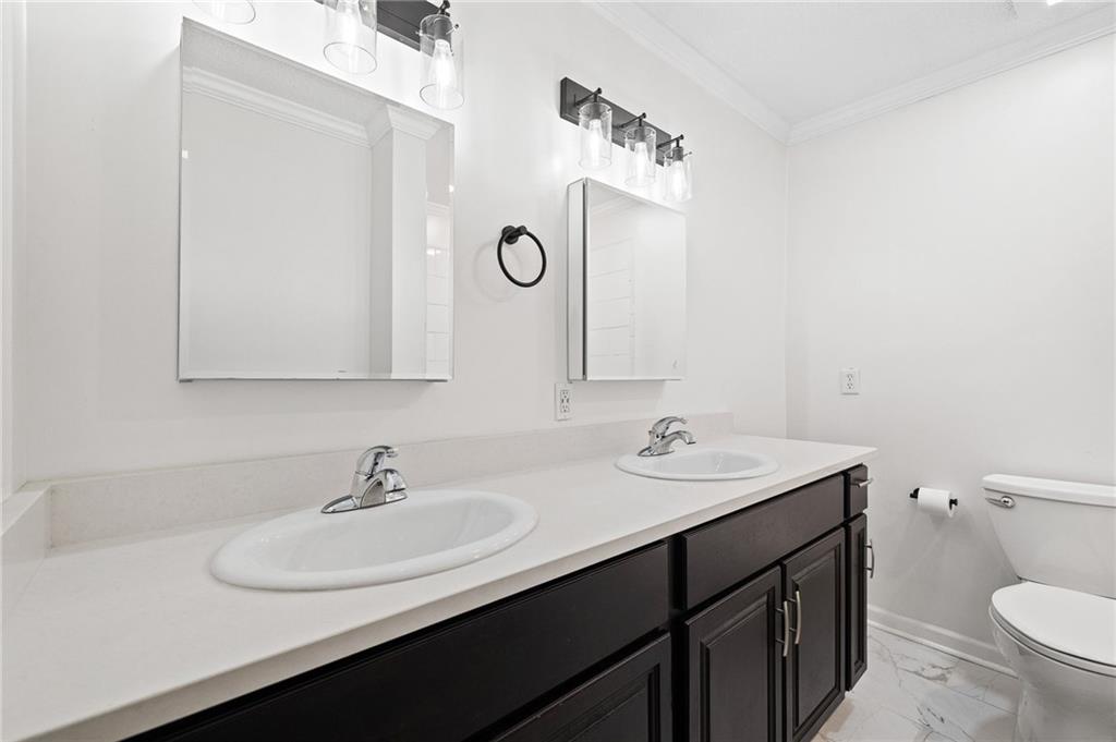 383 Ralph McGill Boulevard Northeast, Unit J Atlanta, GA 30312 - Photo 20 of 33 a bathroom with a toilet sink and mirror