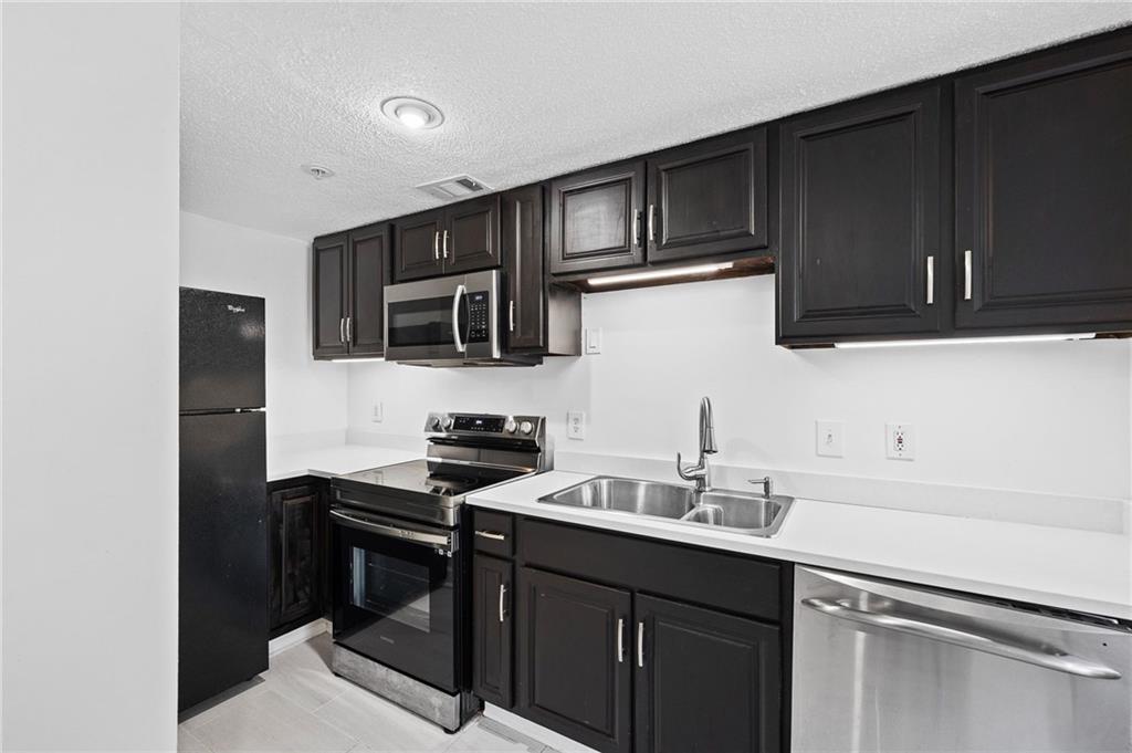 383 Ralph McGill Boulevard Northeast, Unit J Atlanta, GA 30312 - Photo 7 of 28 a kitchen with granite countertop a sink cabinets and stainless steel appliances