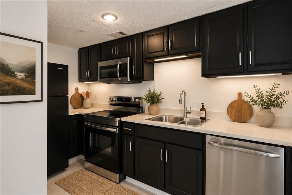 383 Ralph McGill Boulevard Northeast, Unit J Atlanta, GA 30312 - Photo 7 of 33 a kitchen with stainless steel appliances granite countertop a sink stove and microwave