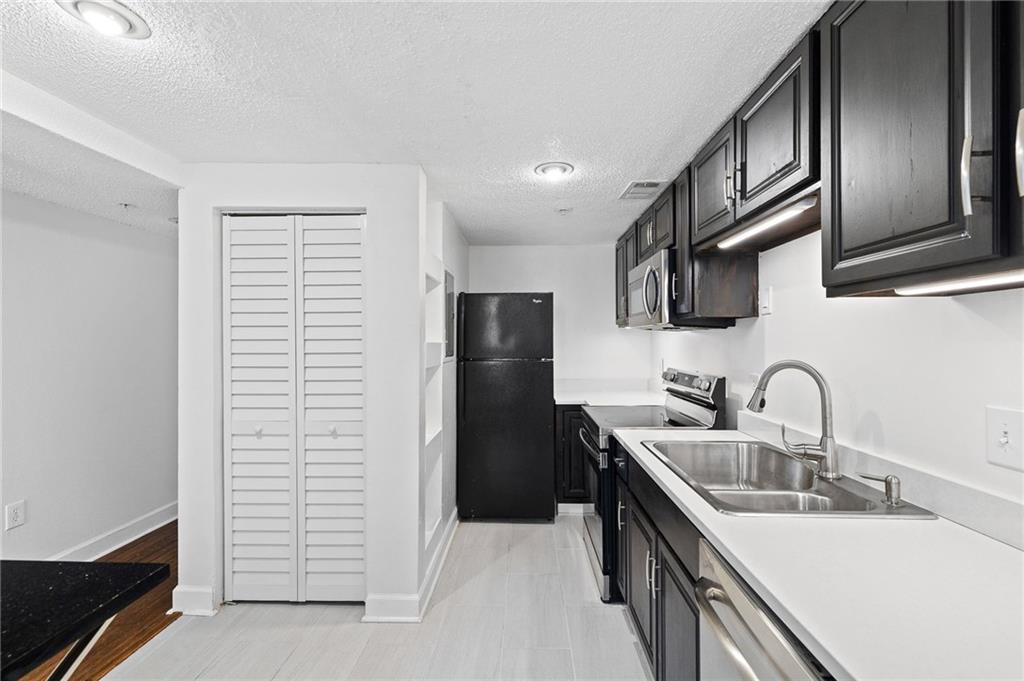 383 Ralph McGill Boulevard Northeast, Unit J Atlanta, GA 30312 - Photo 9 of 28 a kitchen with stainless steel appliances granite countertop a sink stove and refrigerator