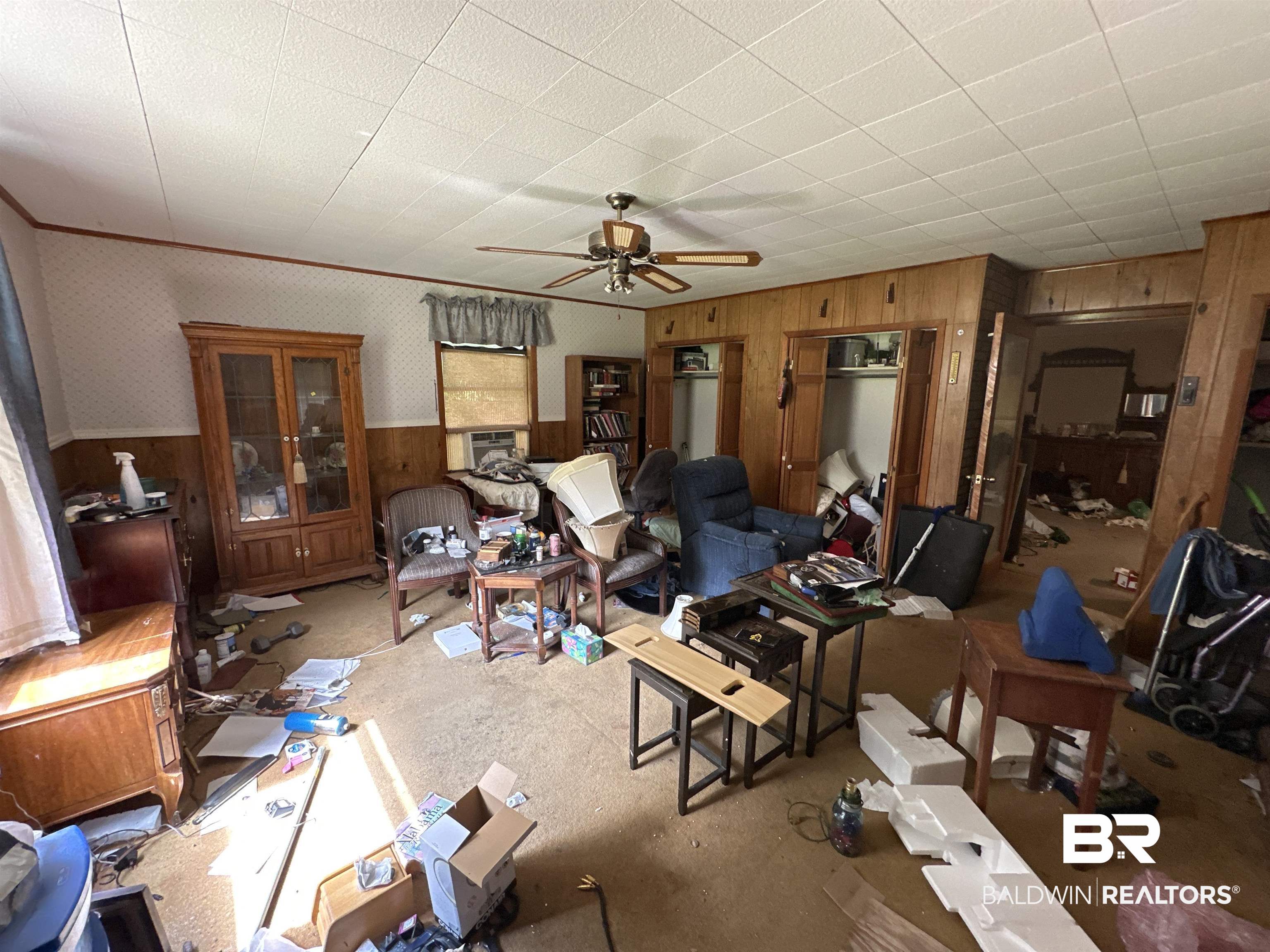 1850 Repoll Drive Mobile, AL 36695 - Photo 10 of 26 Living room featuring cooling unit, wood walls, and ceiling fan