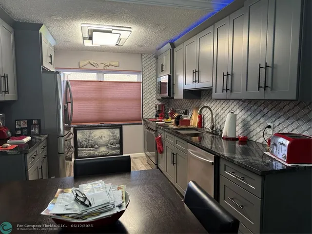 a kitchen with stainless steel appliances granite countertop a stove a sink and a refrigerator