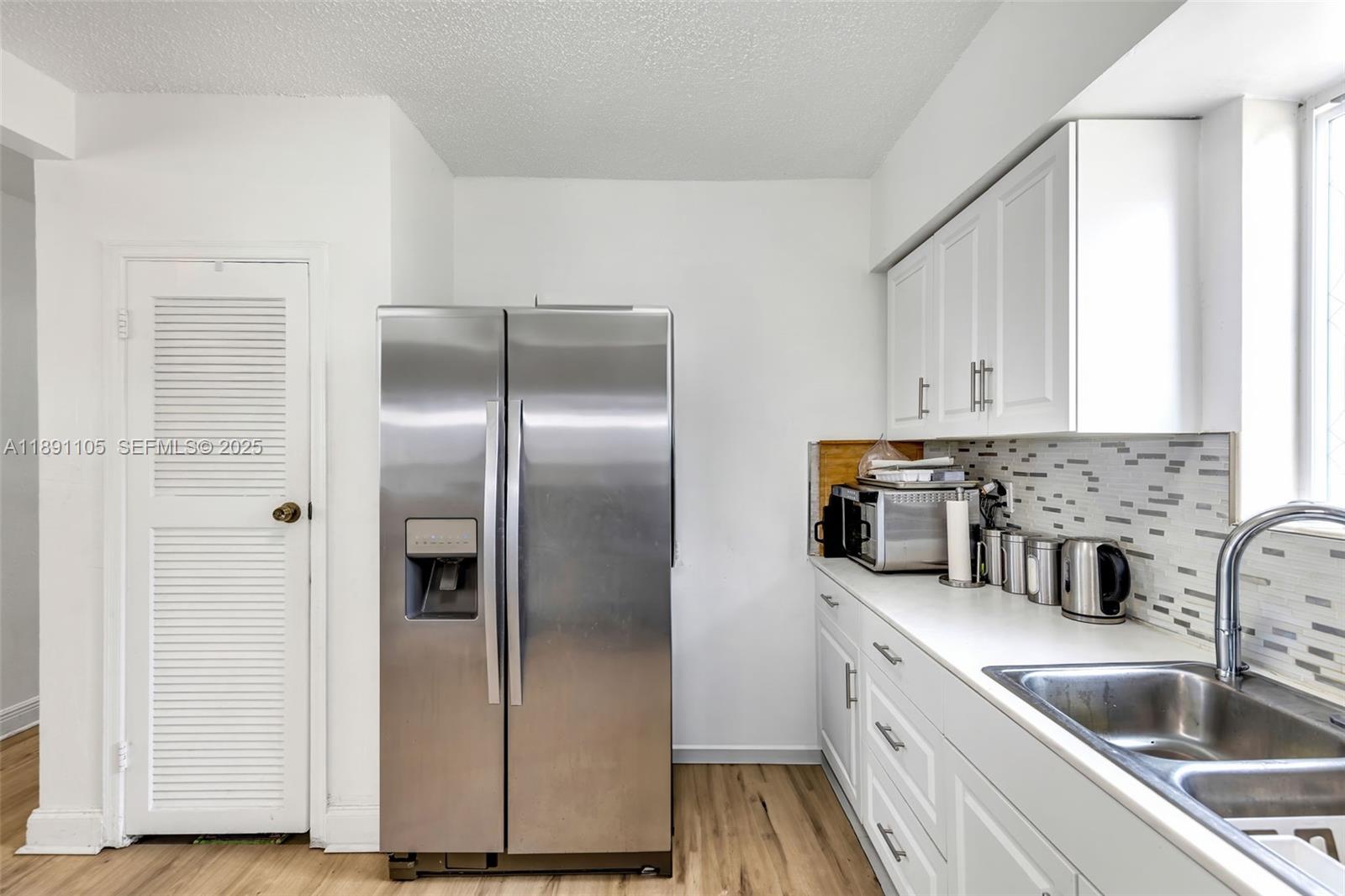 110 Northeast 9th Court Homestead, FL 33030 - Photo 8 of 26 a kitchen with a refrigerator sink and cabinets