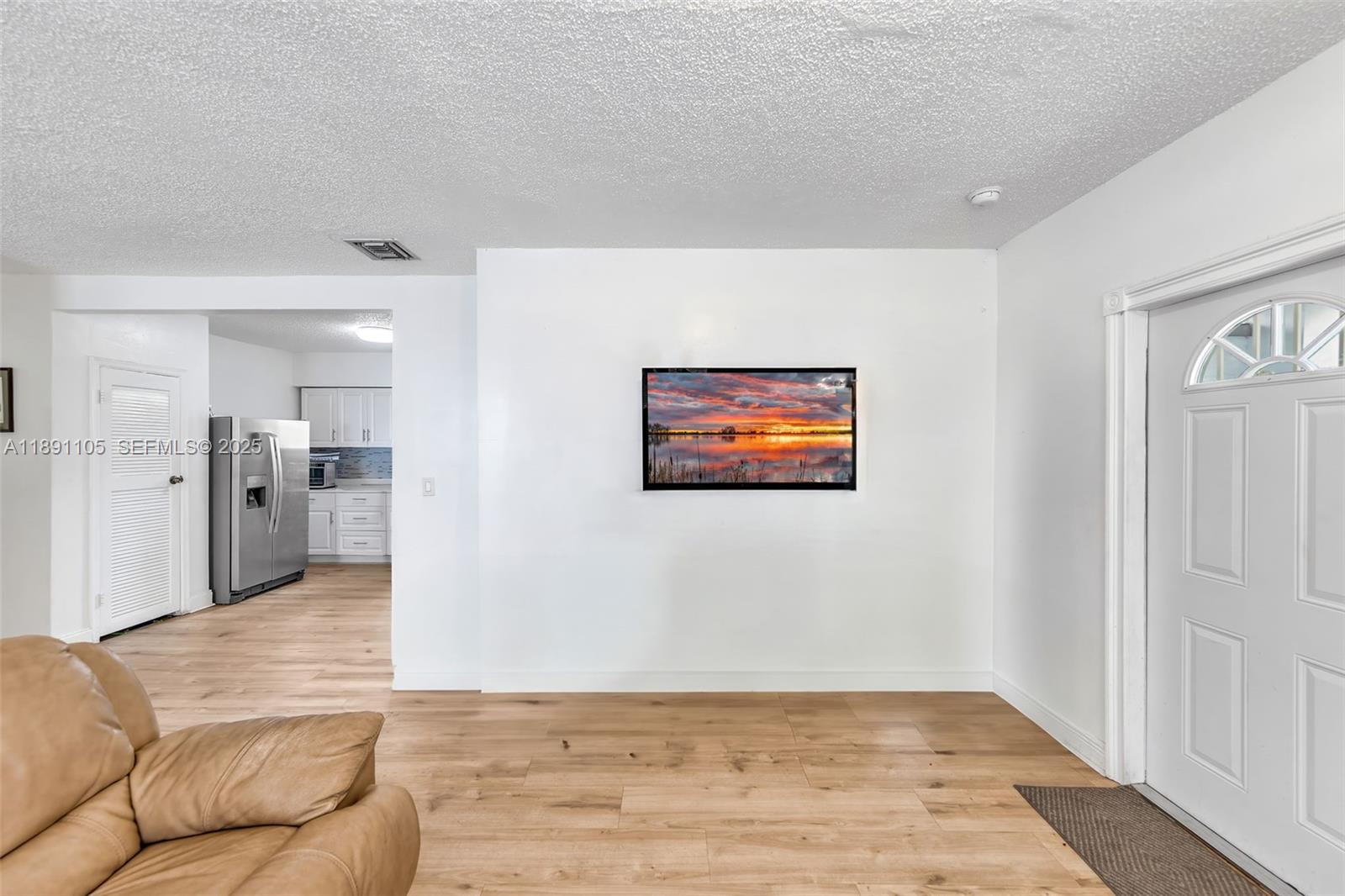 110 Northeast 9th Court Homestead, FL 33030 - Photo 10 of 26 a view of a livingroom with wooden floor and kitchen space