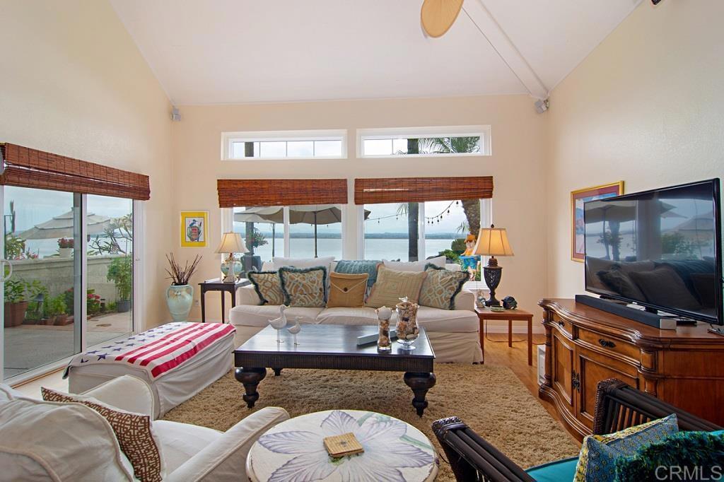 67 Tunapuna Lane Coronado, CA 92118 - Photo 3 of 13 a living room with furniture a flat screen tv and a floor to ceiling window