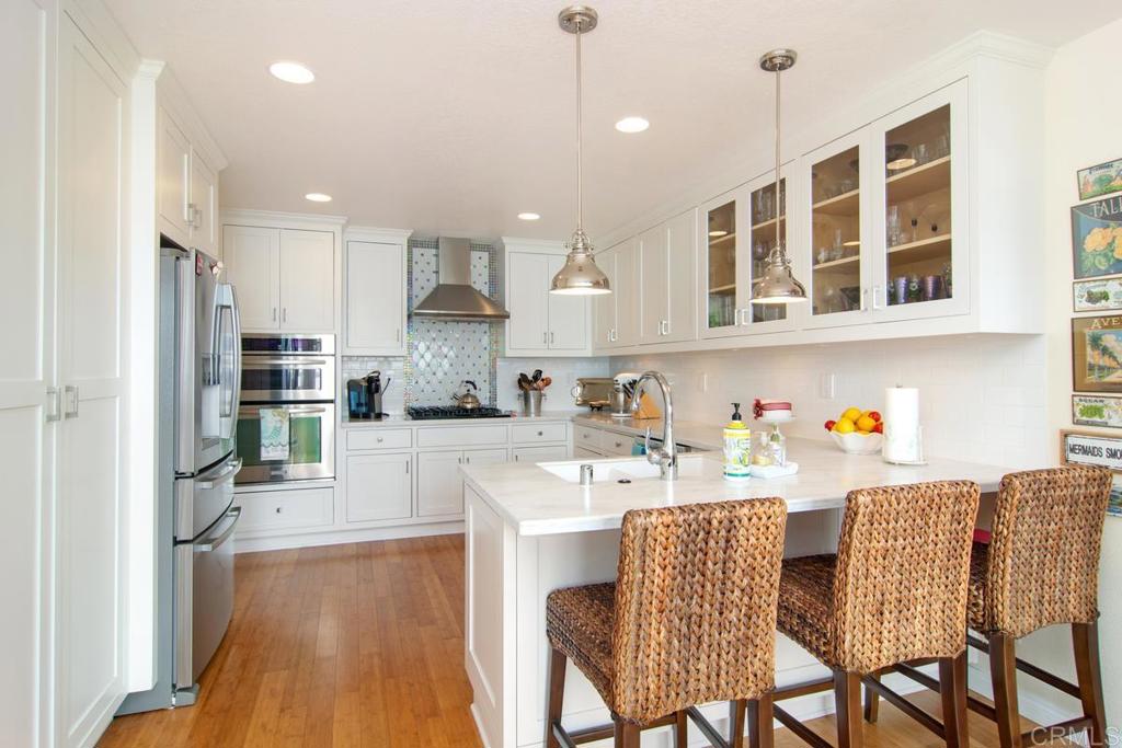 67 Tunapuna Lane Coronado, CA 92118 - Photo 6 of 13 a kitchen with stainless steel appliances granite countertop a dining table chairs refrigerator and sink