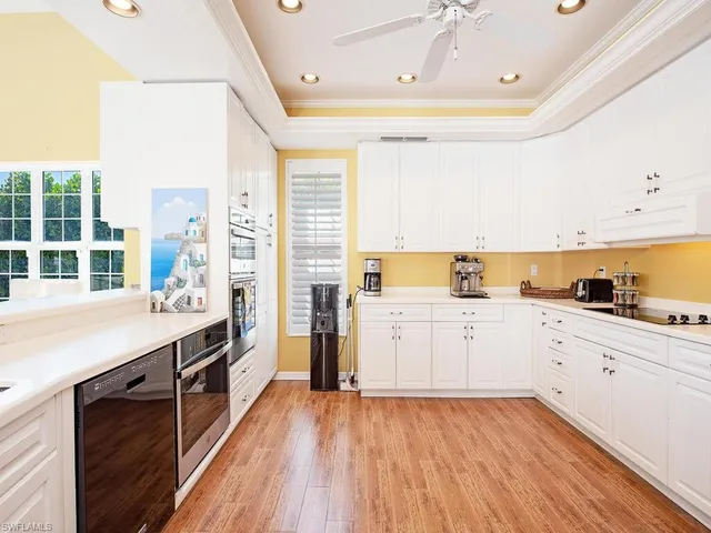 a large kitchen with a wooden floor and cabinets