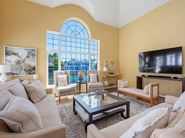 a living room with furniture a flat screen tv and a large window