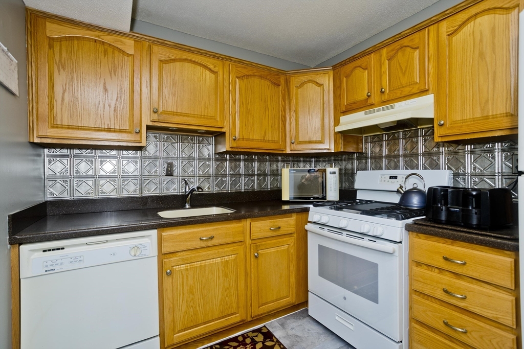 65 Nassau Drive, Unit 65 Springfield, MA 01129 - Photo 15 of 32 a kitchen with granite countertop cabinets stainless steel appliances a sink and cabinets