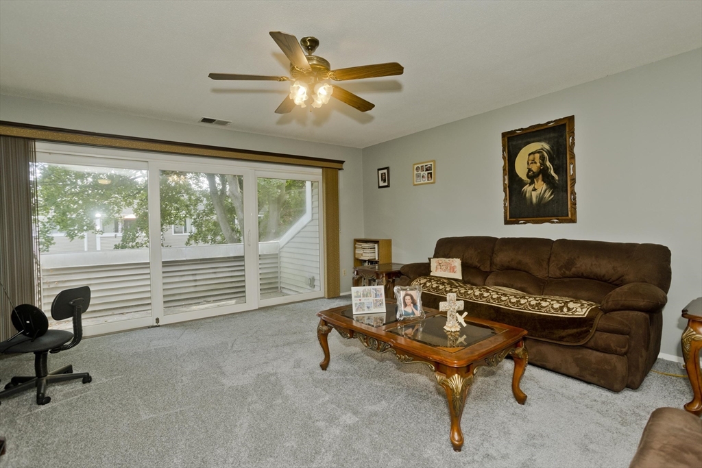 65 Nassau Drive, Unit 65 Springfield, MA 01129 - Photo 6 of 32 a living room with furniture and a floor to ceiling window