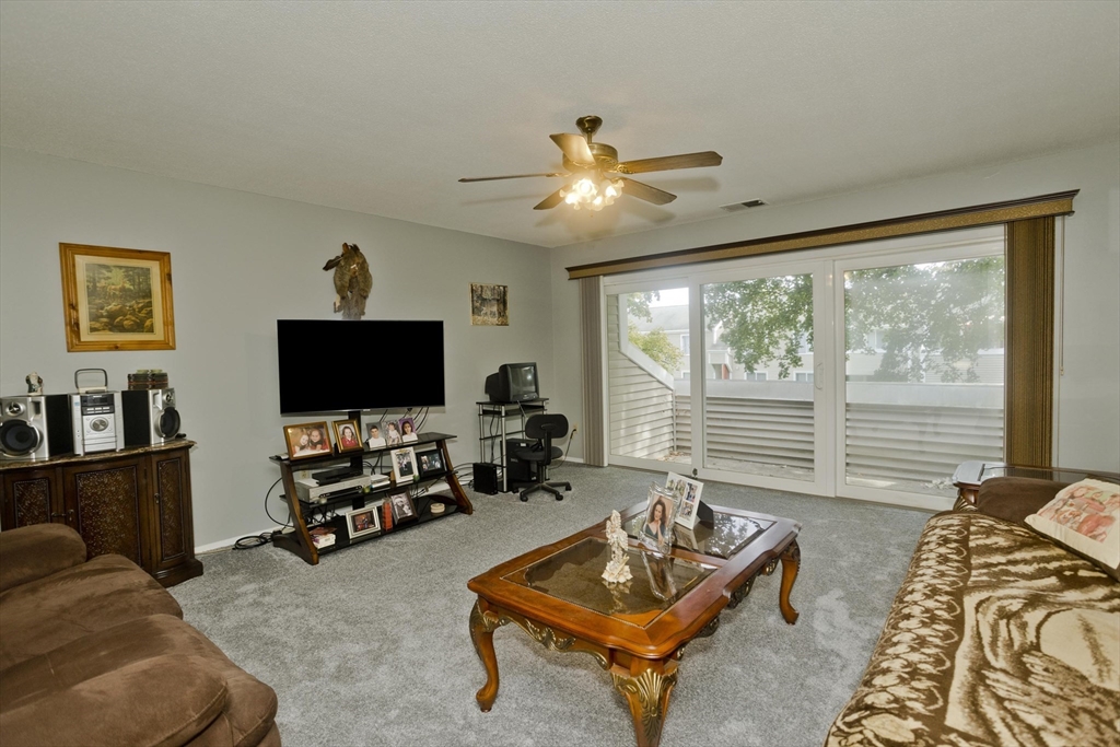 65 Nassau Drive, Unit 65 Springfield, MA 01129 - Photo 7 of 32 a living room with furniture and a flat screen tv