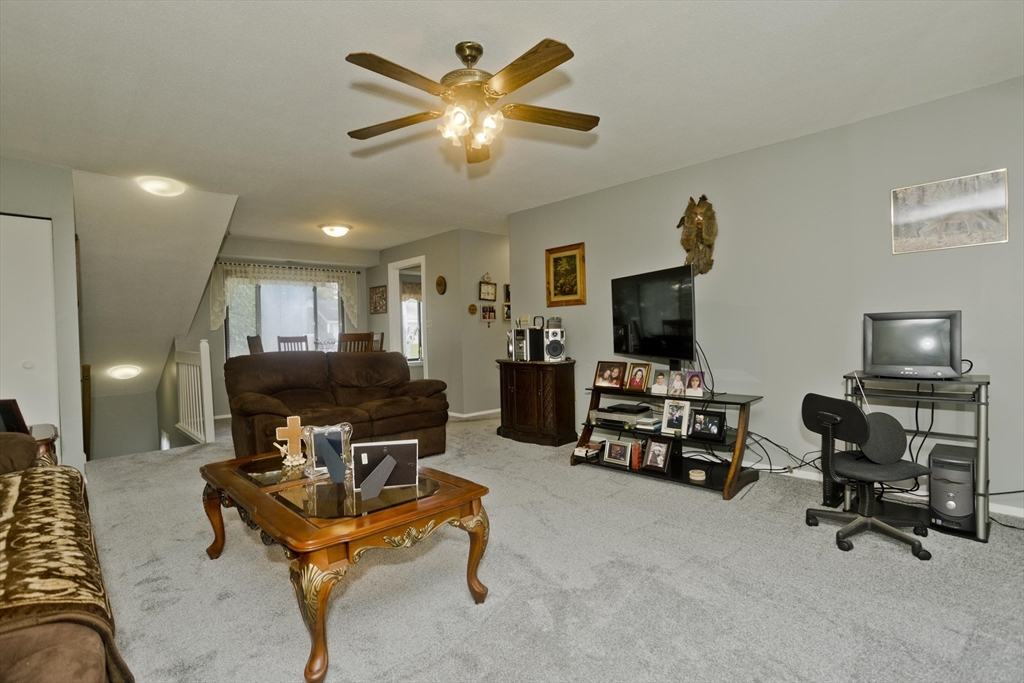 65 Nassau Drive, Unit 65 Springfield, MA 01129 - Photo 8 of 32 a living room with furniture and a flat screen tv
