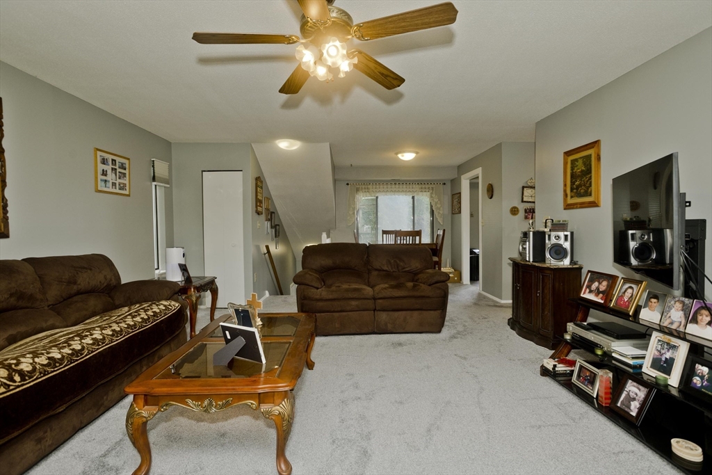 65 Nassau Drive, Unit 65 Springfield, MA 01129 - Photo 10 of 32 a living room with furniture a flat screen tv and a dresser