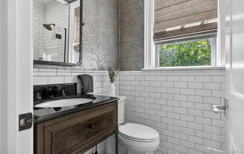 a bathroom with a sink a toilet and a mirror