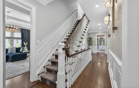 a view of staircase with lots of frames on wall and a window