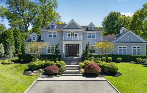 a front view of a house with a yard and potted plants