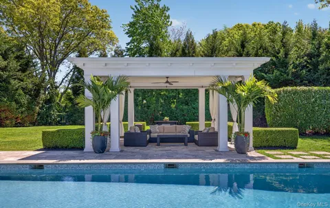 a view of a house with backyard and sitting area