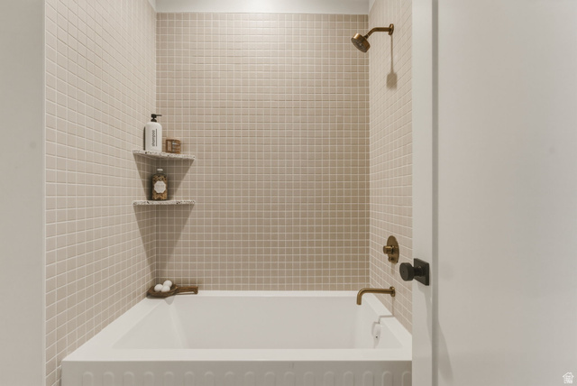 923 North Emery Lane Elk Ridge, UT 84651 - Photo 42 of 101 Tub and shower combination featuring floor-to-ceiling square tile, bronze-finish fixtures, and built-in corner shelving