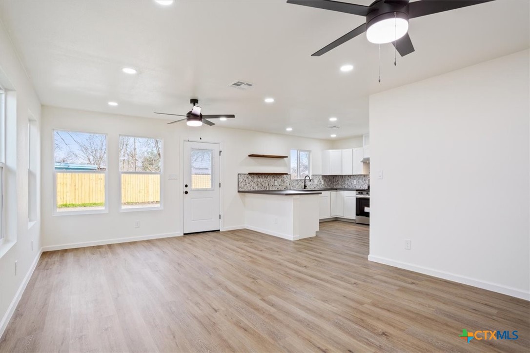 707 South 13th Street Temple, TX 76504 - Photo 6 of 24 a view of kitchen with kitchen island stainless steel appliances wooden floor and window