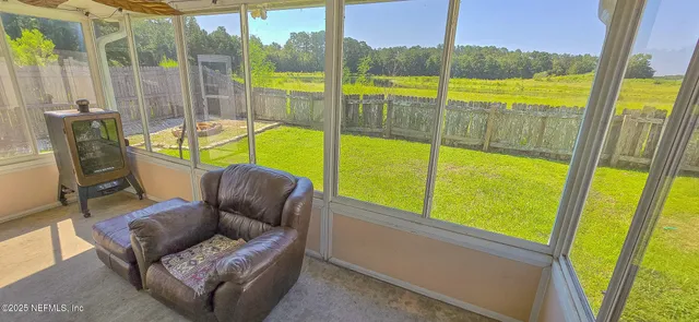 a view of a living room with furniture and floor to ceiling window