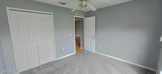 an empty room with chandelier fan