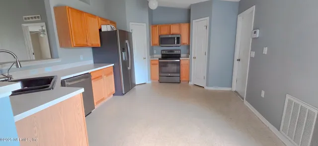 a kitchen with stainless steel appliances granite countertop a refrigerator and a sink