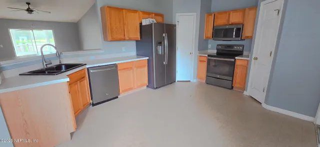 a kitchen with stainless steel appliances granite countertop a refrigerator and a sink