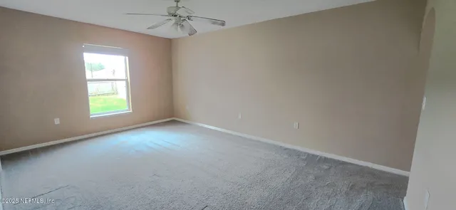 an empty room with a window and a ceiling fan