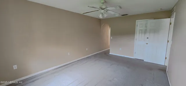 an empty room with a ceiling fan and a window