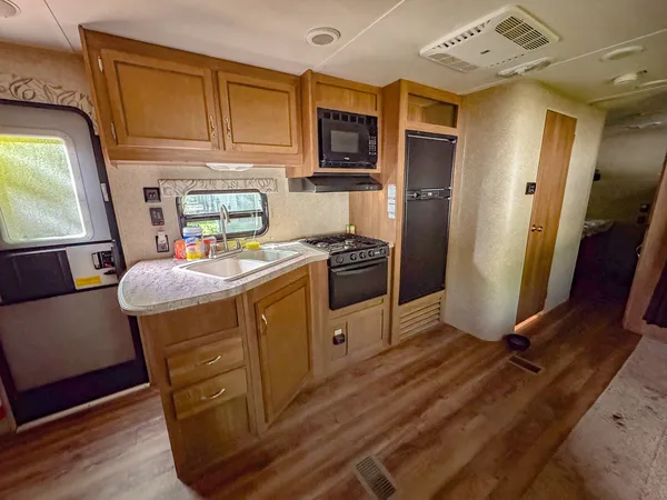 a kitchen with stainless steel appliances granite countertop a refrigerator a stove a sink dishwasher and white cabinets with wooden floor