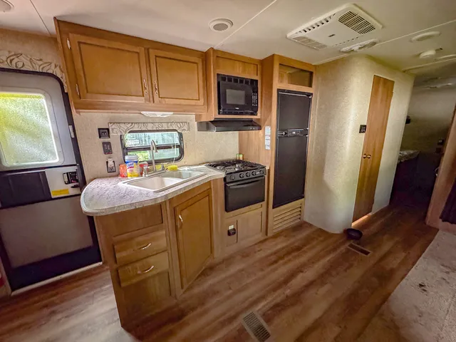 a kitchen with stainless steel appliances granite countertop a refrigerator a stove a sink dishwasher and white cabinets with wooden floor