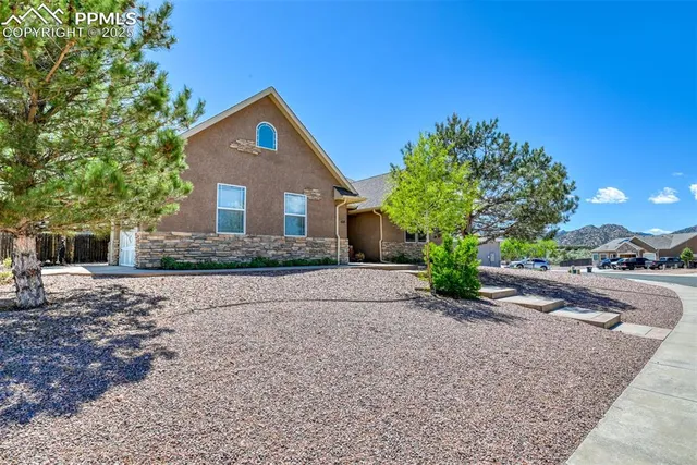 a front view of a house with a yard and trees